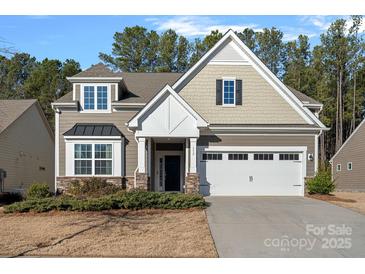 Two-story house with neutral siding, white garage door, and landscaping at 116 Van Gogh Trl, Mount Holly, NC 28120