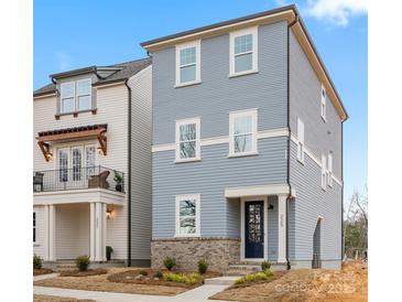 Charming two-story home with blue siding, brick accents, and well-manicured landscaping at 225 Davidson Gateway Dr, Davidson, NC 28036