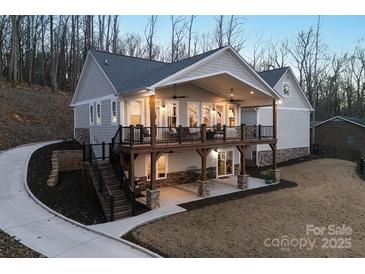 Two-story home with large deck and attached garage, offering lake views at 42610 Moonshine Dr, New London, NC 28127