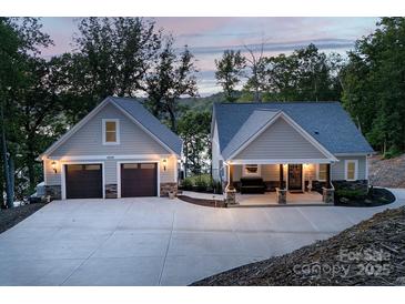 Beautiful home featuring a spacious driveway, attached garage, and welcoming front porch with stone accents at 42610 Moonshine Dr, New London, NC 28127