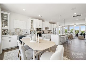 Bright dining area features a modern table and chairs next to the open-concept kitchen at 5037 Westmead Ln, Charlotte, NC 28262