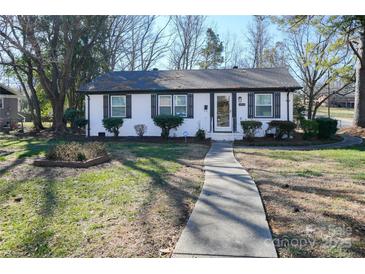 Charming single-story home with a tidy front yard and a walkway leading to the front door at 1233 Rollingwood Dr, Charlotte, NC 28217