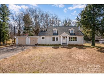 Charming single-story home featuring a detached two-car garage with a basketball hoop and mature trees at 2752 Peachtree Rd, Statesville, NC 28625