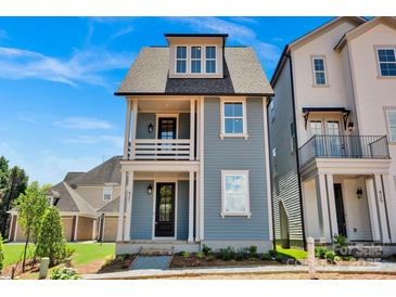 Charming two-story blue home with a front porch and a well-manicured yard at 421 Delburg Mill Alley Dr, Davidson, NC 28036