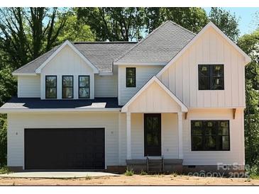 Charming two-story home with white siding, black trim, and a dark garage door provides an inviting curb appeal at 426 Richards Ln, Mooresville, NC 28115