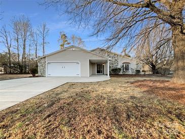 Ranch style home with attached two-car garage and landscaped yard at 500 Kirby Ln, Matthews, NC 28104