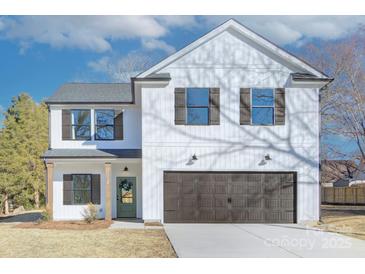Two-story farmhouse style home with dark brown accents and landscaping at 710 N Cedar St, Lincolnton, NC 28092