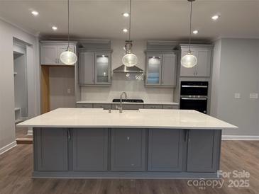 Modern kitchen with gray cabinets, white countertops, and a large island at 9625 Liberty Hill Dr, Mint Hill, NC 28227