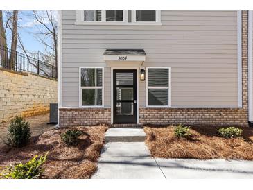 Inviting front entrance with a brick facade and charming landscaping at 3804 Odom Way, Charlotte, NC 28216