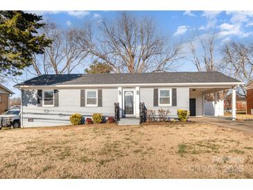 Gray brick ranch house with carport, landscaping, and a spacious front yard at 2016 W Arrowood Rd, Charlotte, NC 28217