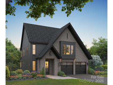 Two-story home with dark gray siding, brick accents, and a three-car garage at 3025 Kinger Ln, Matthews, NC 28105