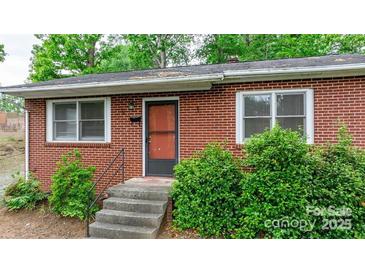 Brick ranch house with steps leading to the front door, surrounded by landscaping at 61 17Th Street Nw Pl, Hickory, NC 28601