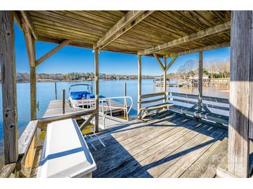 Covered boat dock with seating and water access at 130 Sandy Shore Dr, Mooresville, NC 28117