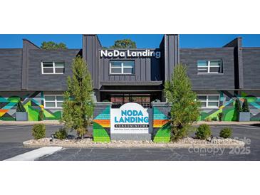 Attractive building exterior with unique architectural elements, colorful murals, and professional landscaping at 2000 Patio Ct # 129, Charlotte, NC 28205
