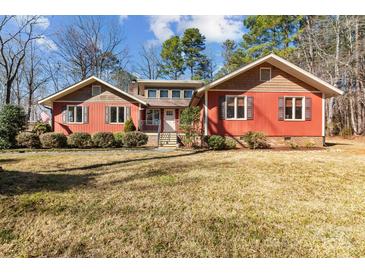 Ranch style home with red siding, mature landscaping, and a spacious yard at 3406 Red Fox Trl, Weddington, NC 28104