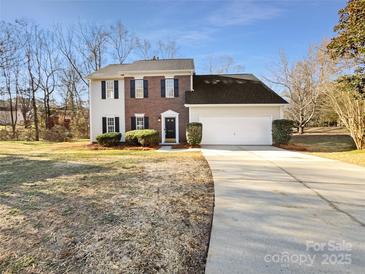 Two-story brick and vinyl sided home with attached garage and landscaping at 11006 Renoir Ct, Charlotte, NC 28215