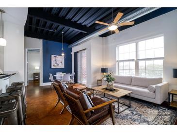 Open-concept living space with a stylish sofa, chairs, and a view into the dining and kitchen at 2338 Yadkin Ave # 203, Charlotte, NC 28205