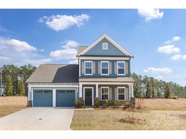 Charming two-story home with blue siding, a two-car garage, and manicured landscaping at 24078 Sailfish Dr # 1152, Lancaster, SC 29720