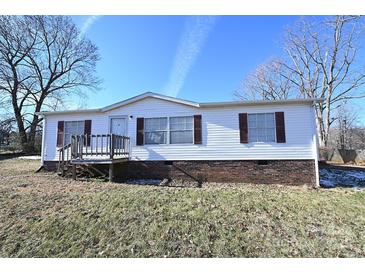 White single-wide mobile home with brown shutters and a wooden deck at 3463 Rock Creek Dr, Newton, NC 28658