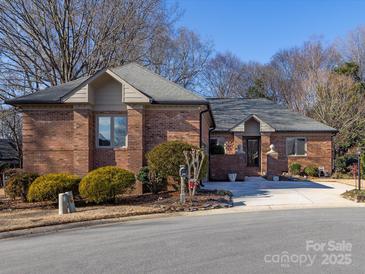 Brick ranch home with landscaped yard and driveway at 3680 Bermuda Nw Ct, Concord, NC 28027