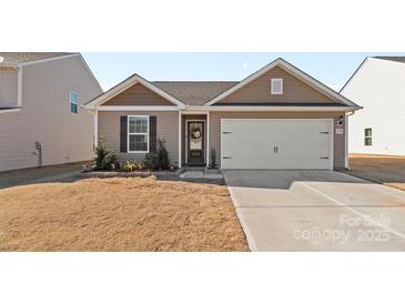 One-story home with neutral siding, landscaping, and a two-car garage at 1729 Nia Rd, Charlotte, NC 28215