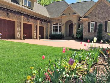 Brick home with three-car garage, landscaped yard, and inviting front porch at 270 Bent Tree Dr, Stanley, NC 28164