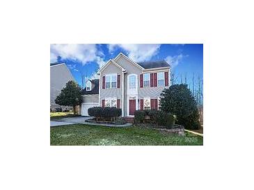 Charming two-story home boasts a manicured lawn, symmetrical design, and classic red shutters at 4030 Garden Oak Dr, Indian Trail, NC 28079