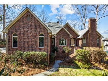 Charming red brick home with a well-maintained lawn and mature landscaping, perfect for curb appeal at 411 Major Run, Cramerton, NC 28032