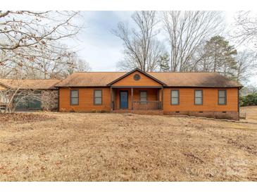 Ranch style home with orange siding, a covered porch, and a brick foundation at 664 Freemont Dr, Lancaster, SC 29720