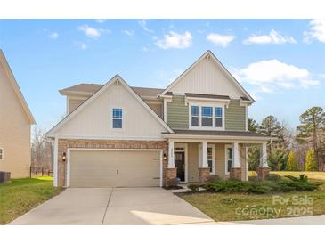 Charming two-story home featuring stone accents, attached two car garage and covered front porch at 2006 Houle Ln, Charlotte, NC 28214