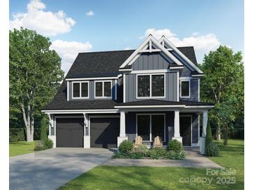 Charming two-story home with dark gray siding, a two-car garage, and a manicured front lawn at 2629 Ritz Ln, Matthews, NC 28105