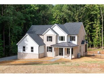 New two-story home featuring a brick and white facade, a black roof and shutters, and a covered front porch entry at 4251 Candlewood Dr, Sherrills Ford, NC 28673