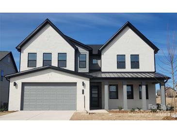 New two-story home featuring a modern design, painted brick, and a two-car garage at 604 Hyder Trl, Tega Cay, SC 29708