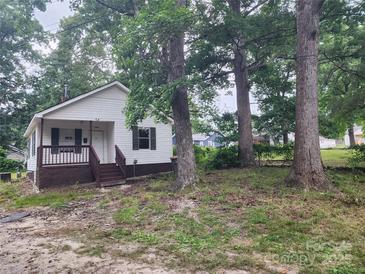White house with brown trim, front porch, and large trees in the yard at 1300 Brookdale St, Kannapolis, NC 28083