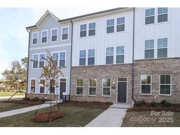 Two-story townhome with gray siding and brick accents at 5004 Rill Ct # 37, Charlotte, NC 28262
