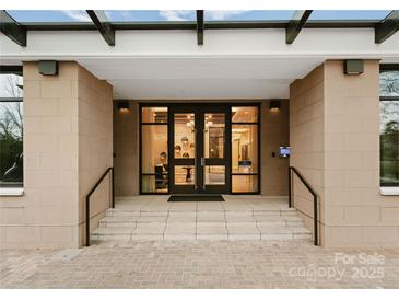 Elegant entryway featuring glass doors, stone accents, and accessible ramp with handrails at 130 Cherokee Rd # 104, Charlotte, NC 28207