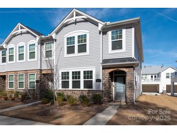 Charming two-story townhome featuring stone accents and a well-maintained lawn on a sunny day at 1342 Galloway Rd # 132, Charlotte, NC 28262