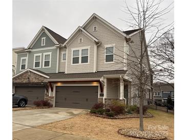 Two-story townhome with gray siding, stone accents, and a two-car garage at 2517 Lydia Ave, Charlotte, NC 28205