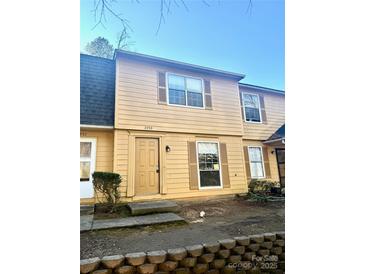 Two-story yellow home with a gray roof and small front yard at 3959 Briarhill Dr, Charlotte, NC 28215