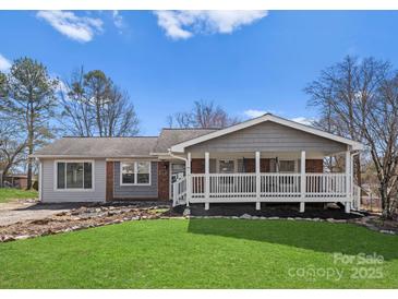 Charming single-story home with a welcoming front porch, lush lawn, and freshly manicured landscaping at 443 Picadilly Ln, Troutman, NC 28166