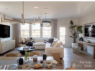 Spacious living room features a large sectional sofa, wood coffee table, and stylish decor at 7015 Impulse Ct, Charlotte, NC 28205