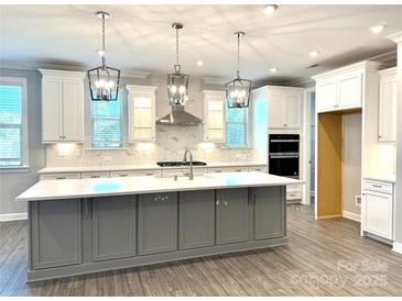 Bright kitchen featuring a large island, stainless steel appliances, pendant lighting and modern finishes at 9657 Liberty Hill Dr, Mint Hill, NC 28227