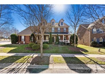 Charming two-story brick home with a welcoming front porch and well-manicured lawn at 103 Glenholden Ln, Mooresville, NC 28115