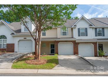 Inviting townhome exterior with brick and vinyl siding, two-car garage, and landscaping at 10841 Twisted Bark Ln, Charlotte, NC 28213