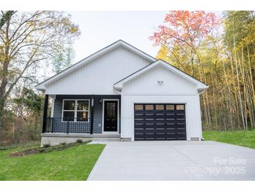 Charming house with gray and white siding, black garage door, and a well-manicured lawn at 1460 23Rd Sw St, Hickory, NC 28602