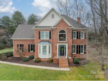 Brick two-story house with a large front yard and landscaping at 15604 Wynford Hall St, Huntersville, NC 28078