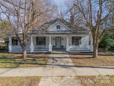 Charming white house with a wraparound porch and well-manicured lawn at 506 S Chester St, Gastonia, NC 28052