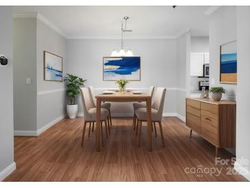 Bright dining room featuring hardwood floors and modern light fixture at 5617 Fairview Rd # 9, Charlotte, NC 28209