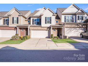 Modern two-story townhome with attached garage and well-manicured landscaping at 6417 Union Station Ct, Charlotte, NC 28210