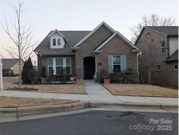 Brick home with front porch and landscaped yard at 703 Marion Dr, Matthews, NC 28105